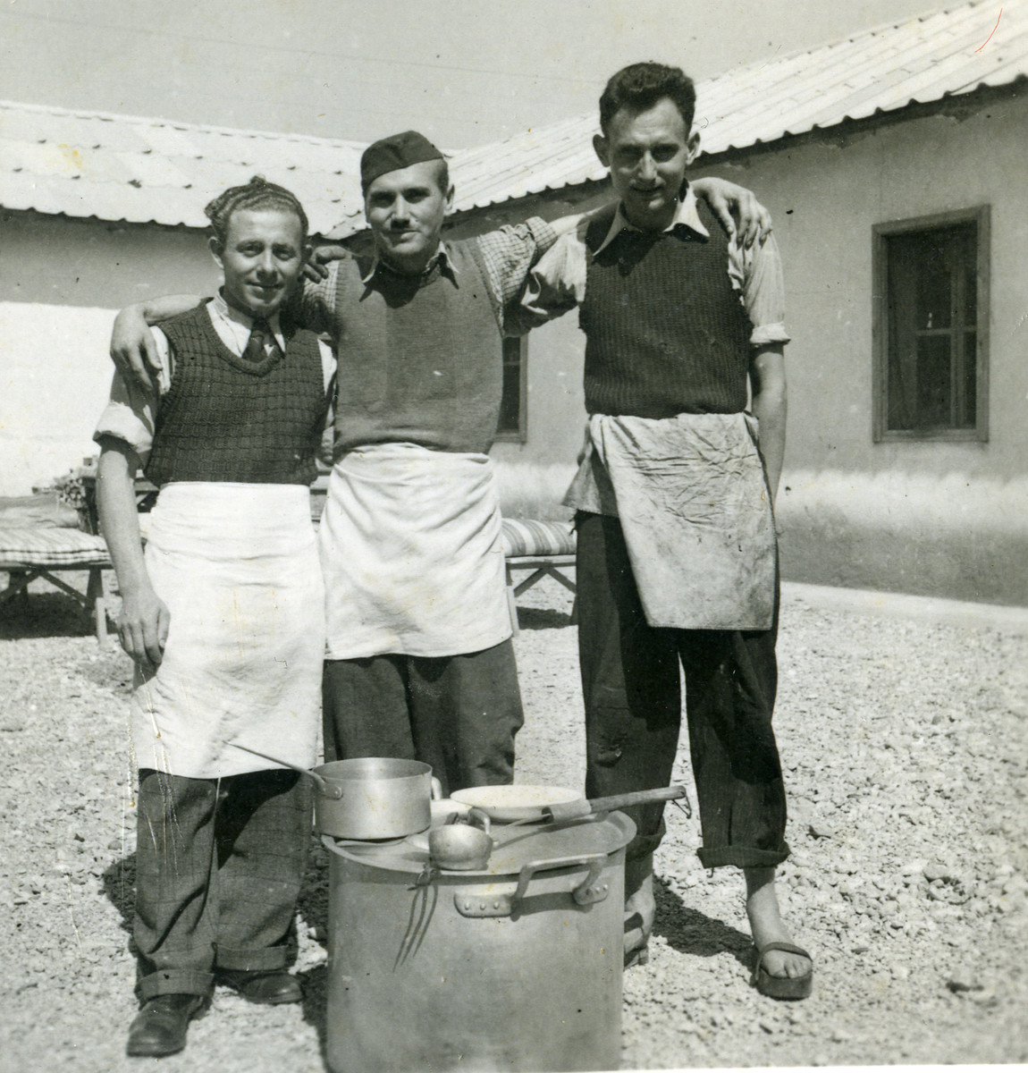 Three men pose at Ferramonti