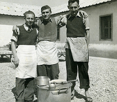 Three men pose at Ferramonti