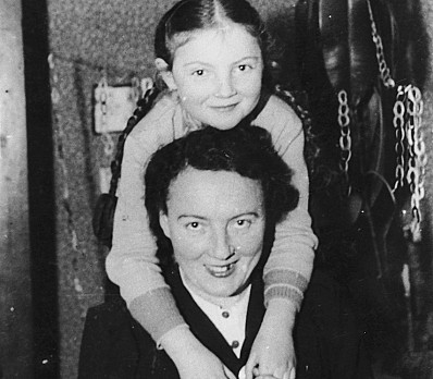 Young girl embracing her mother, 1939